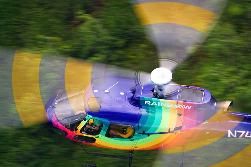 Rainbow Helicopter above forest on Oahu