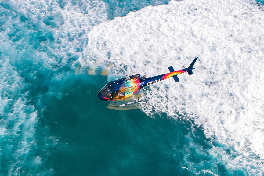 Rainbow Helicopters above ocean waves and blue water