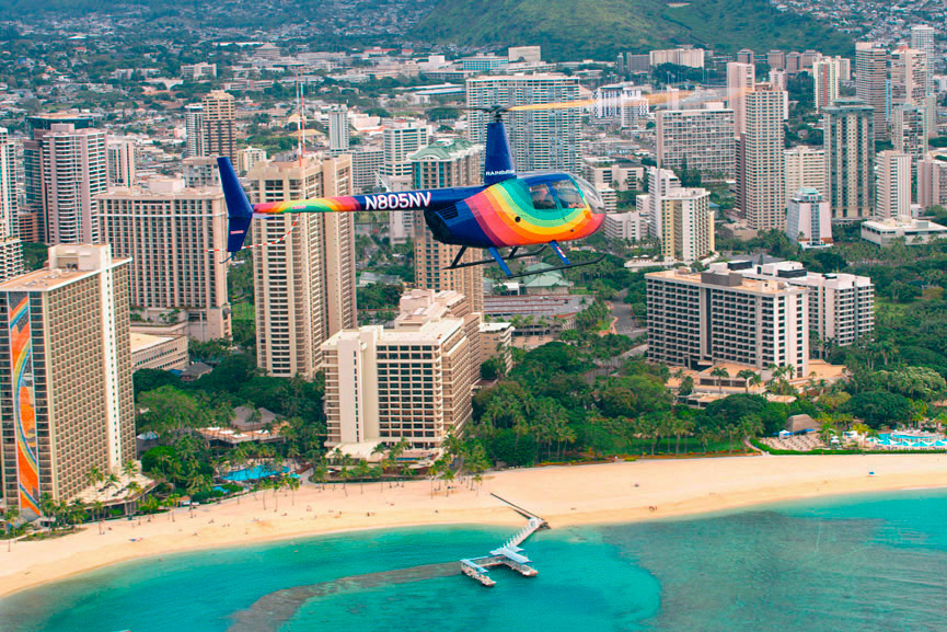 A Rainbow Helicopter flying past the Aloha Tower, Waikiki