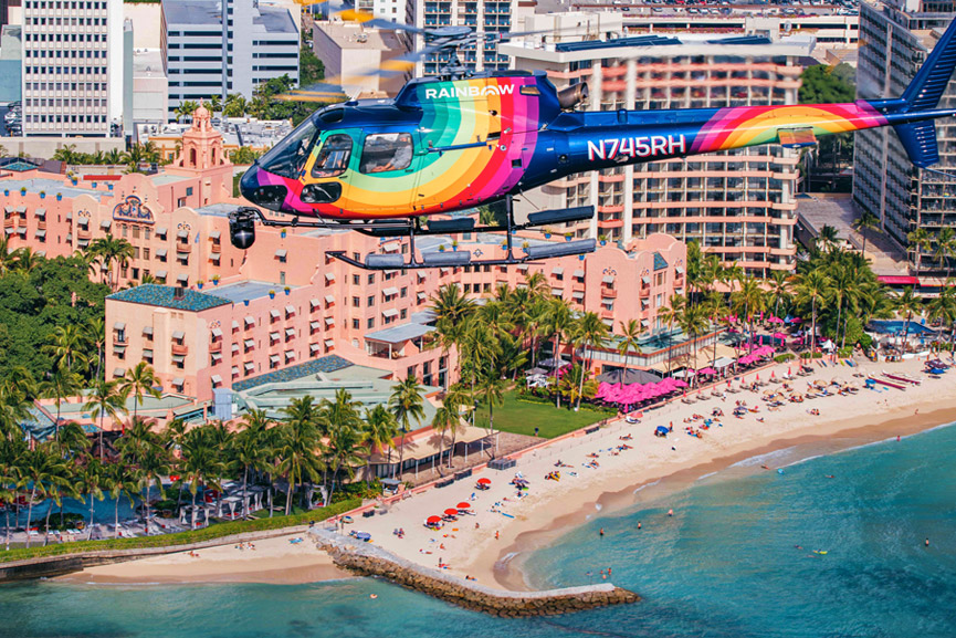 Rainbow Painted Helicopter flying above sandy beaches in Waikiki