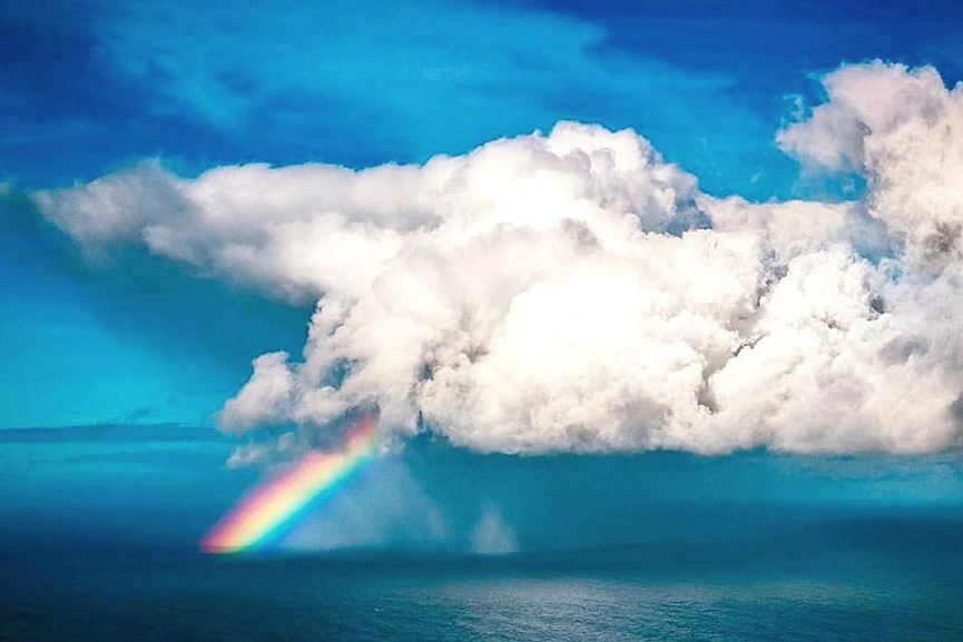 Rainbow above the ocean seen from helicopter