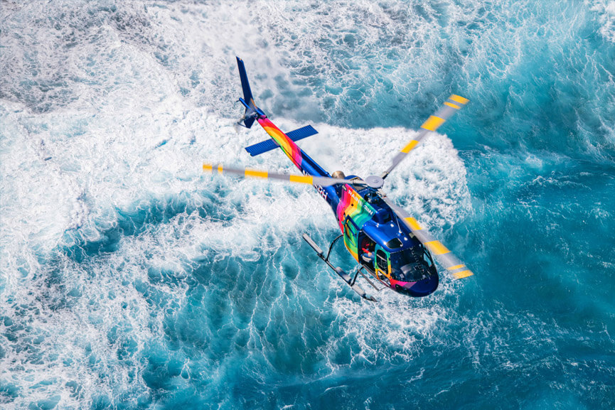Rainbow Helicopter flying over Waikiki coastline