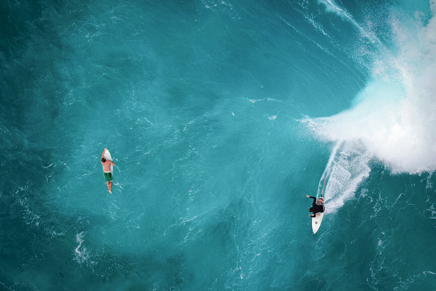 Photograph of surfers in the ocean seen from a helicopter ride in Waikiki