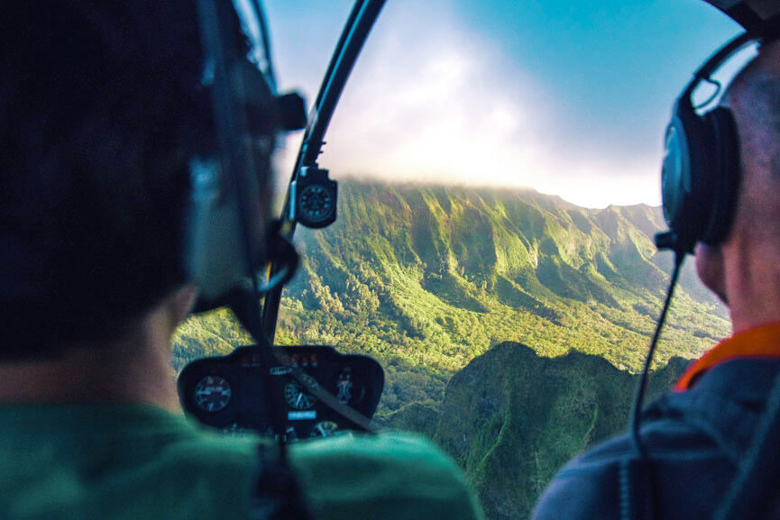 A pair of people riding in a Rainbow Helicopter overlooking a beautiful valley landscape