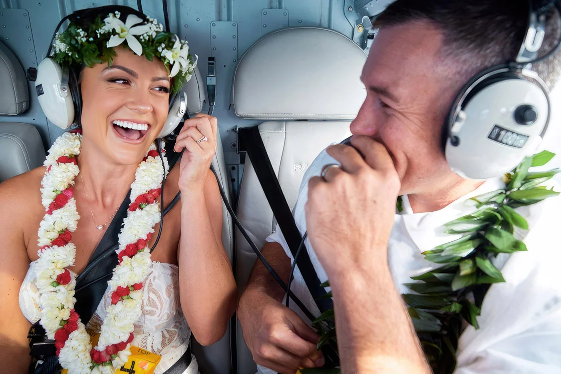 A couple sharing a fun, moment on a Rainbow Helicopter tour of Oahu, Hawaii.