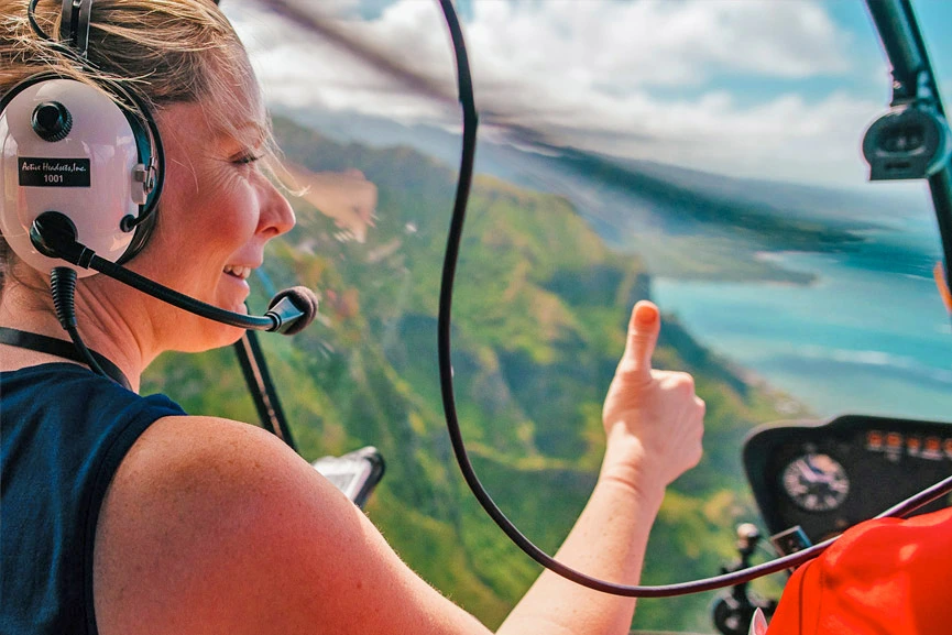 Oahu helicopter tour guest giving thumbs up to pilot
