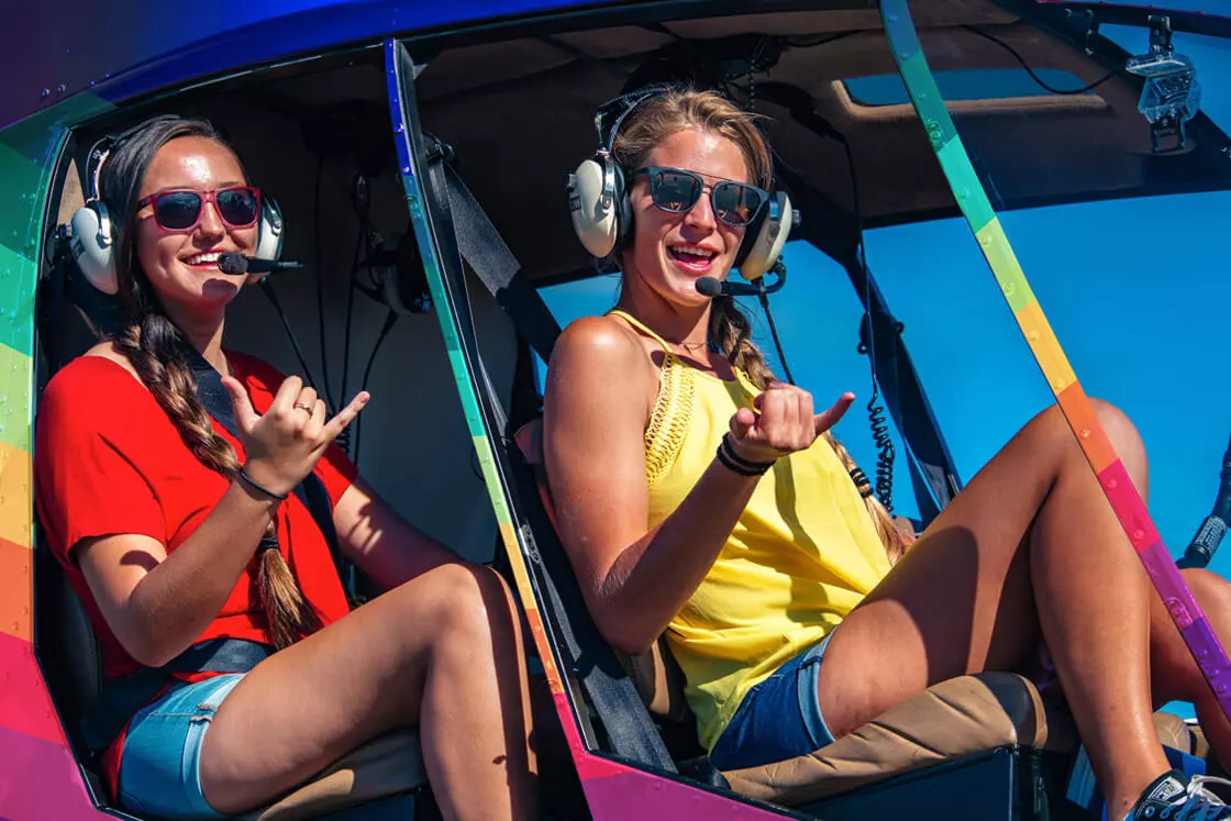 Two young women showing shaka symbol in a Rainbow Helicopter