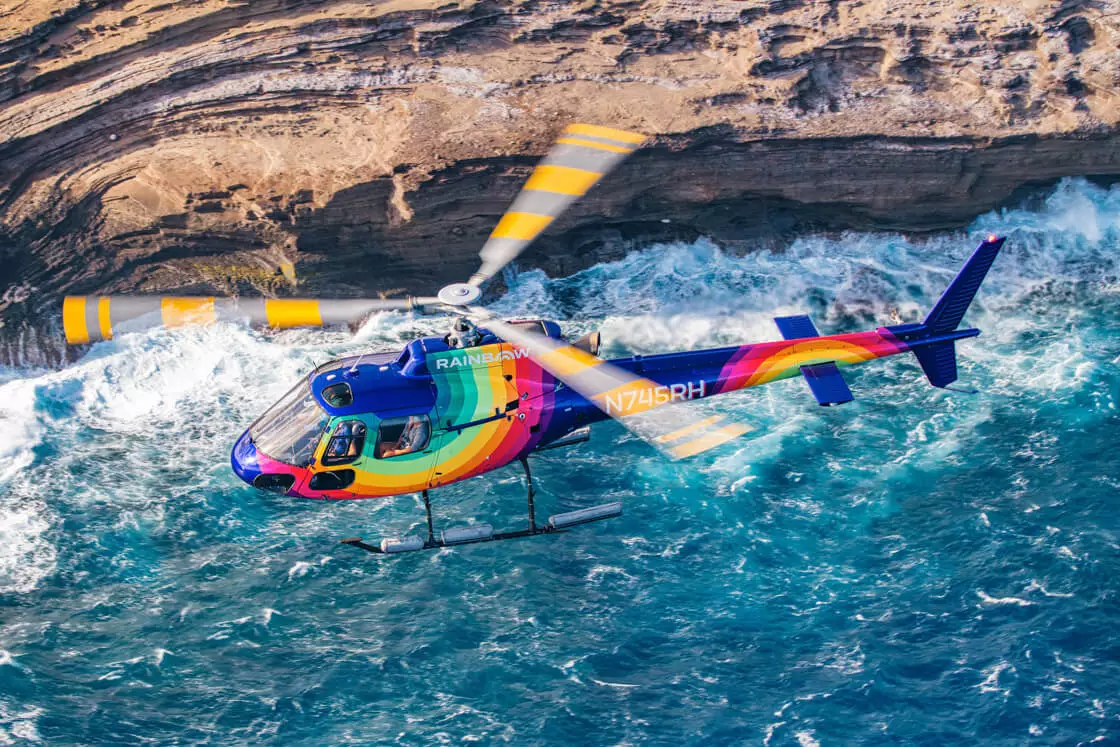 Rainbow Helicopter flying over ocean