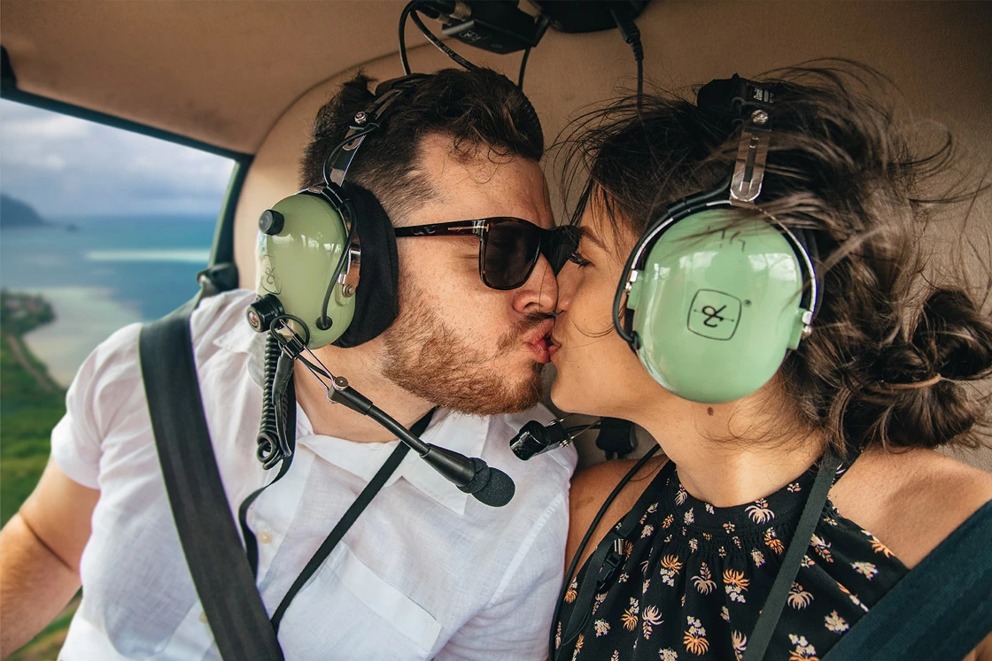 A couple sharing a kiss on a Rainbow Helicopter tour