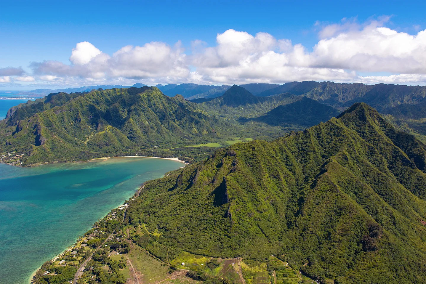 Aerial photography of Oahu by helicopter of coastline and iconic mountain ranges