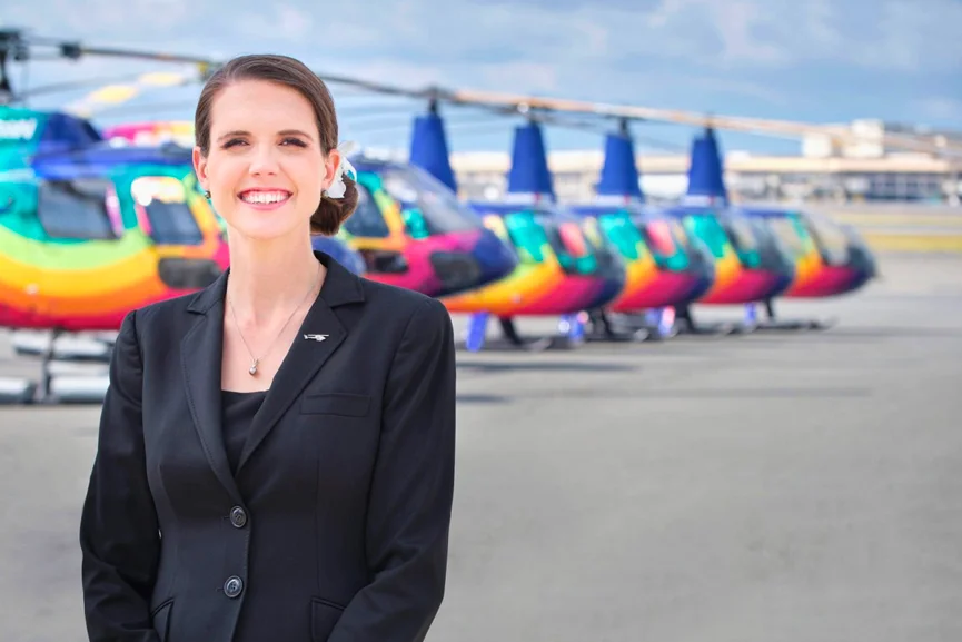 Rainbow Helicopters founder and owner Nicole Battjes in front of a fleet of Rainbow Helicopters in Oahu 2023, featured in an article in Rotor Media called 'vertical aviation is vital'